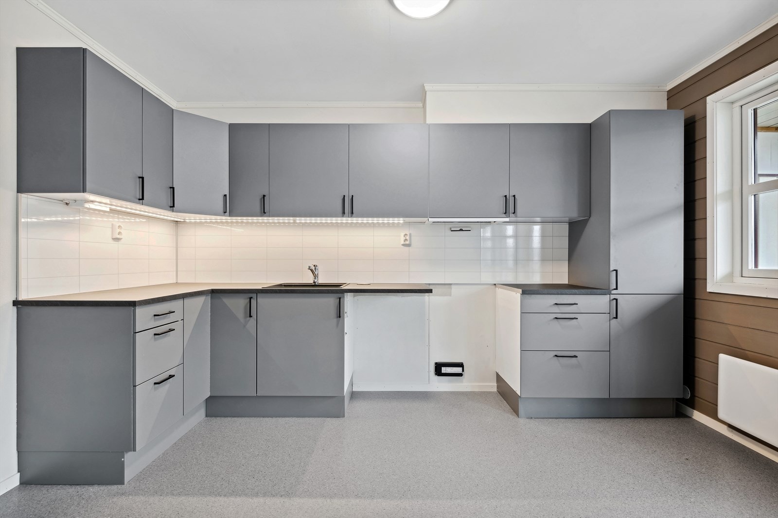 Nyere kjøkkeninnredning med plass og opplegg for komfyr og oppvaskmaskin. Galleribilde