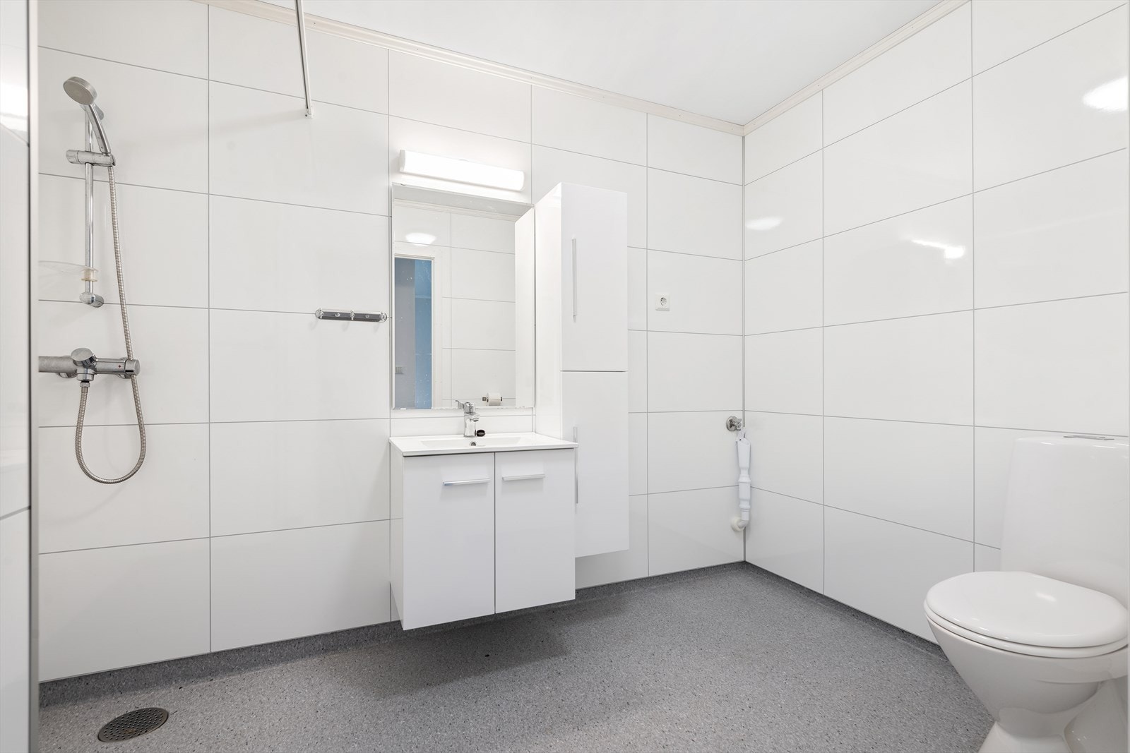 Badet har belegg på gulv og plater på vegg. Galleribilde