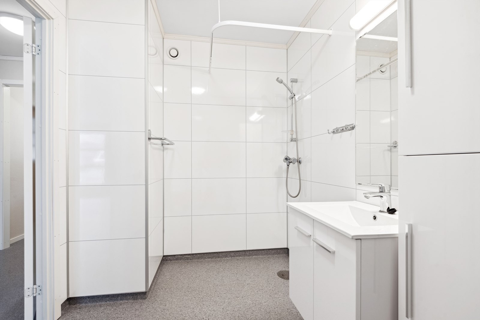 Badet er innredet med dusj, baderomsinnredning med servant og gulvmontert toalett. Galleribilde