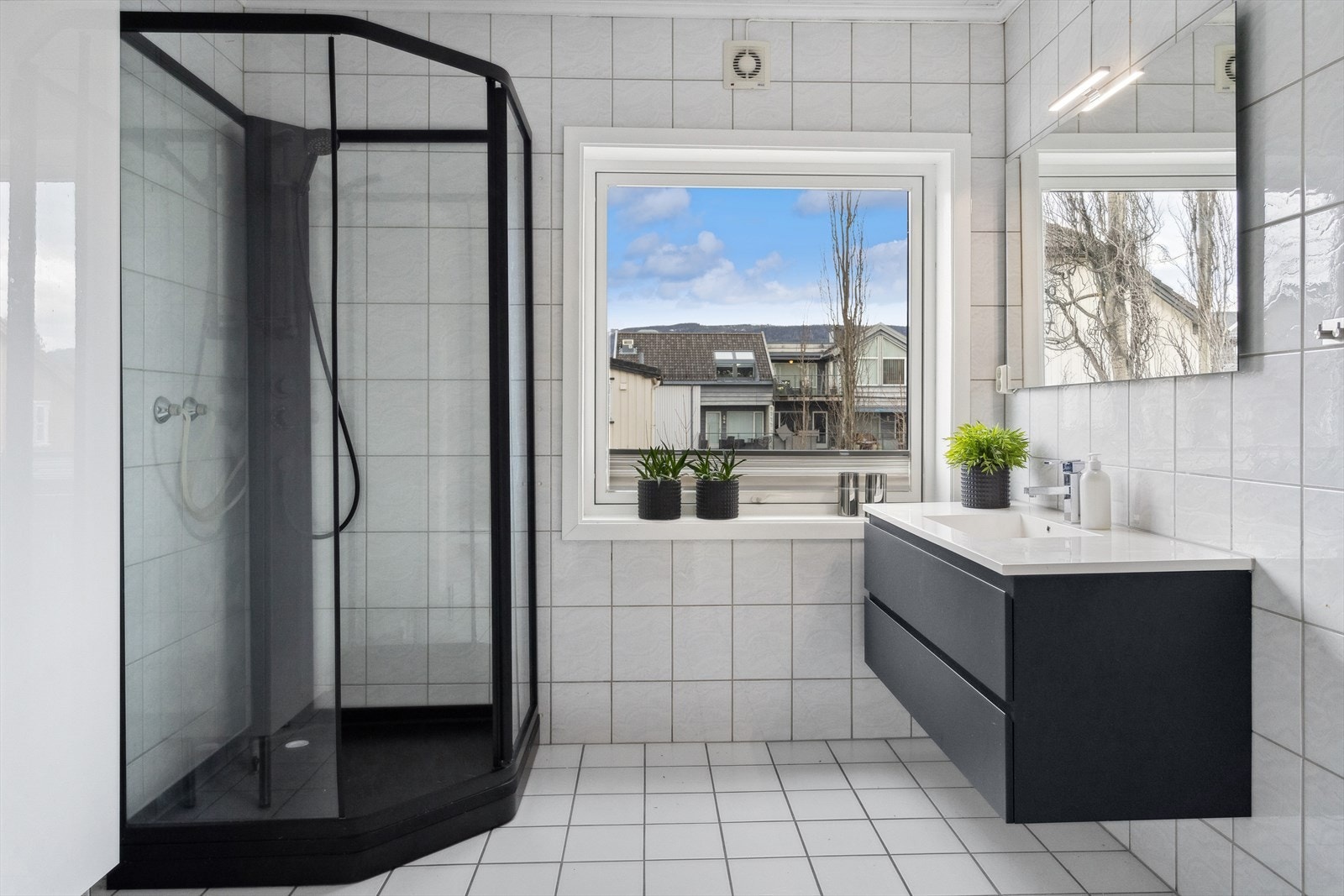 Badet innehar dusjkabinett, toalett, innredning med heldekkende servant, speil med belysning over og opplegg for vaskemaskin. Galleribilde