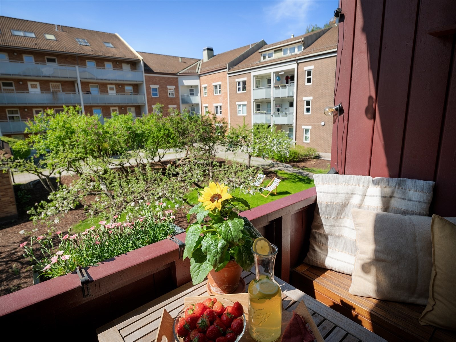 Her sitter du godt skjermet, og med et behagelig pusterom til nabobygget. Utenfor balkongen er det en velstelt felles hage med blomsterbed, epletrær, lekeplass og benker. Galleribilde