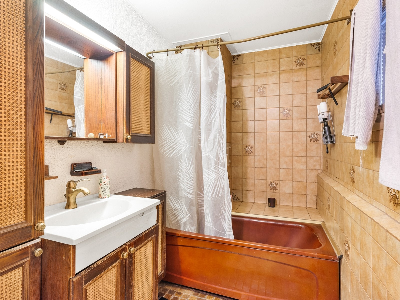 To-delt eldre flislagt baderom fra ca. 1982, med toalett, servant og badekar. Galleribilde