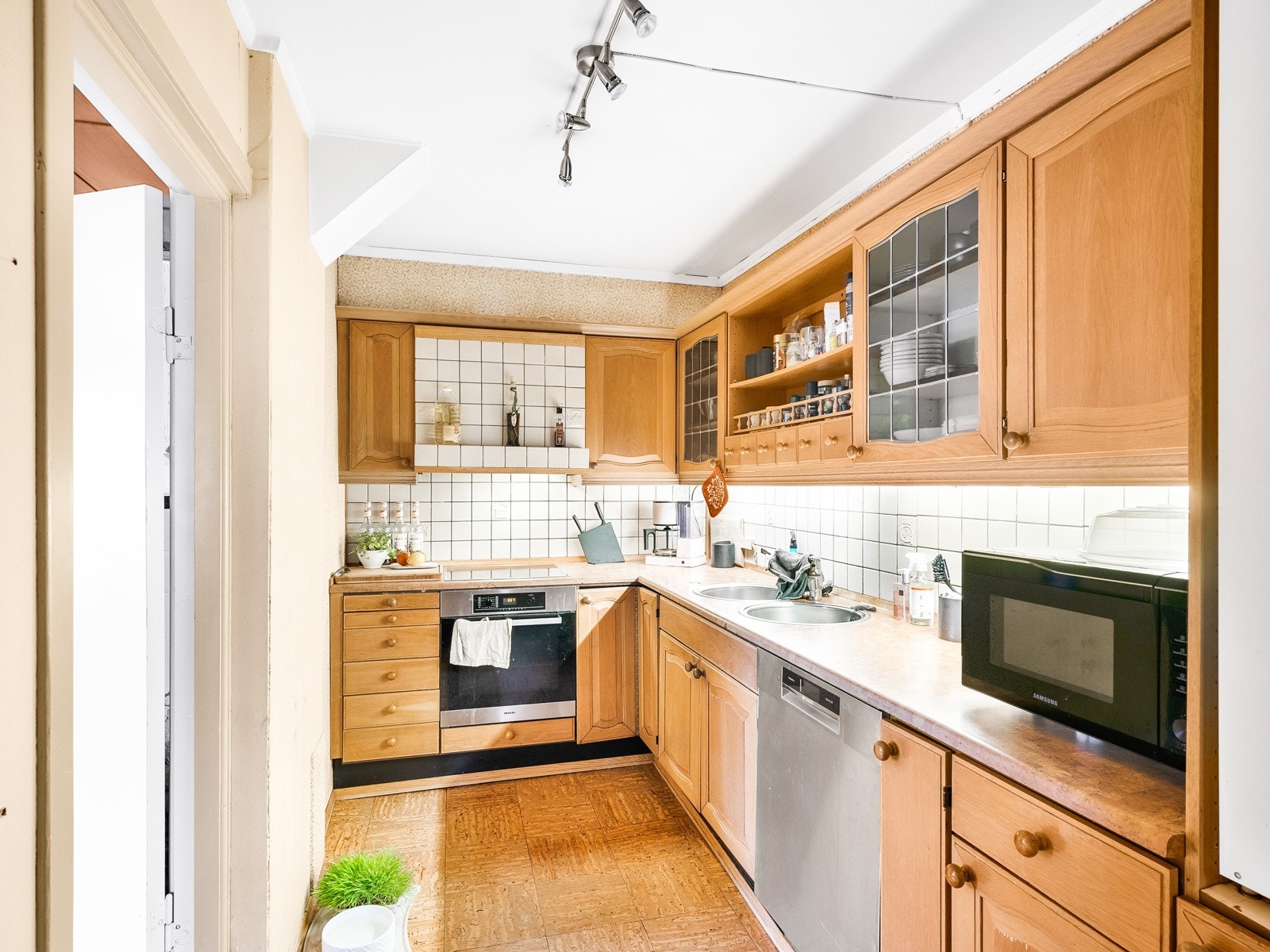 Kjøkkeninnredning med profilerte fronter, og benkeplate av laminat med to nedfelte runde stålservanter. Galleribilde