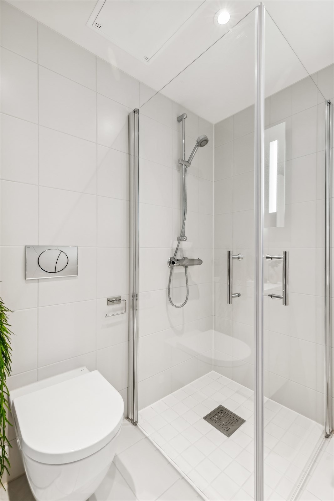 Innredningen er bestående av servantskap i hvit glatt høyglans med heldekkende servant, stort speil, vegghengt wc, dusjhjørne med svingdører og opplegg for vaskemaskin. Galleribilde