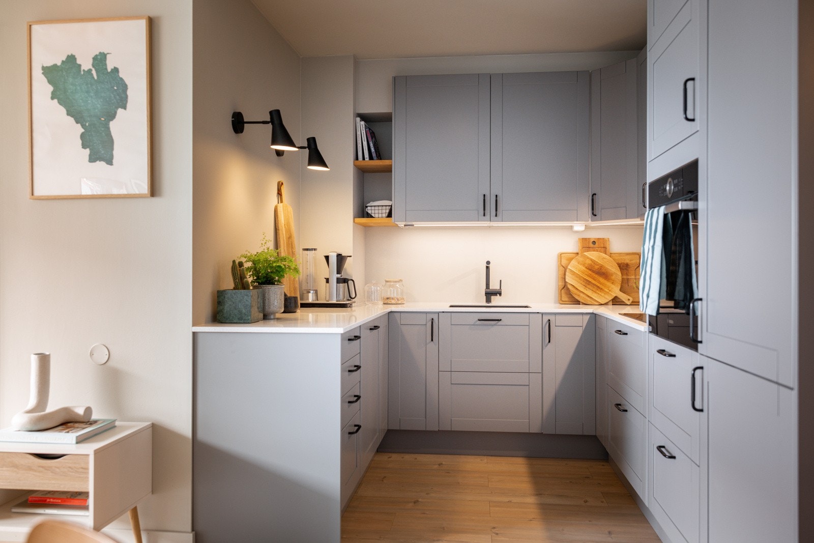 Kjøkkeninnredningen har profilerte fronter i grå utførelse og benkeplate i kompositt. Galleribilde