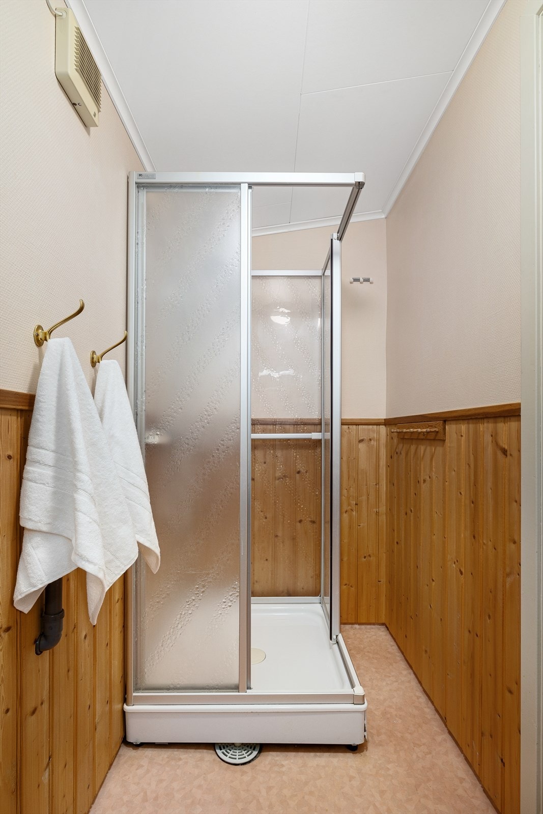 Det er montert laminert benkeplate med nedsenket servant og ett-greps blandebatteri samt dusjkabinett. Overskap og speil. Galleribilde