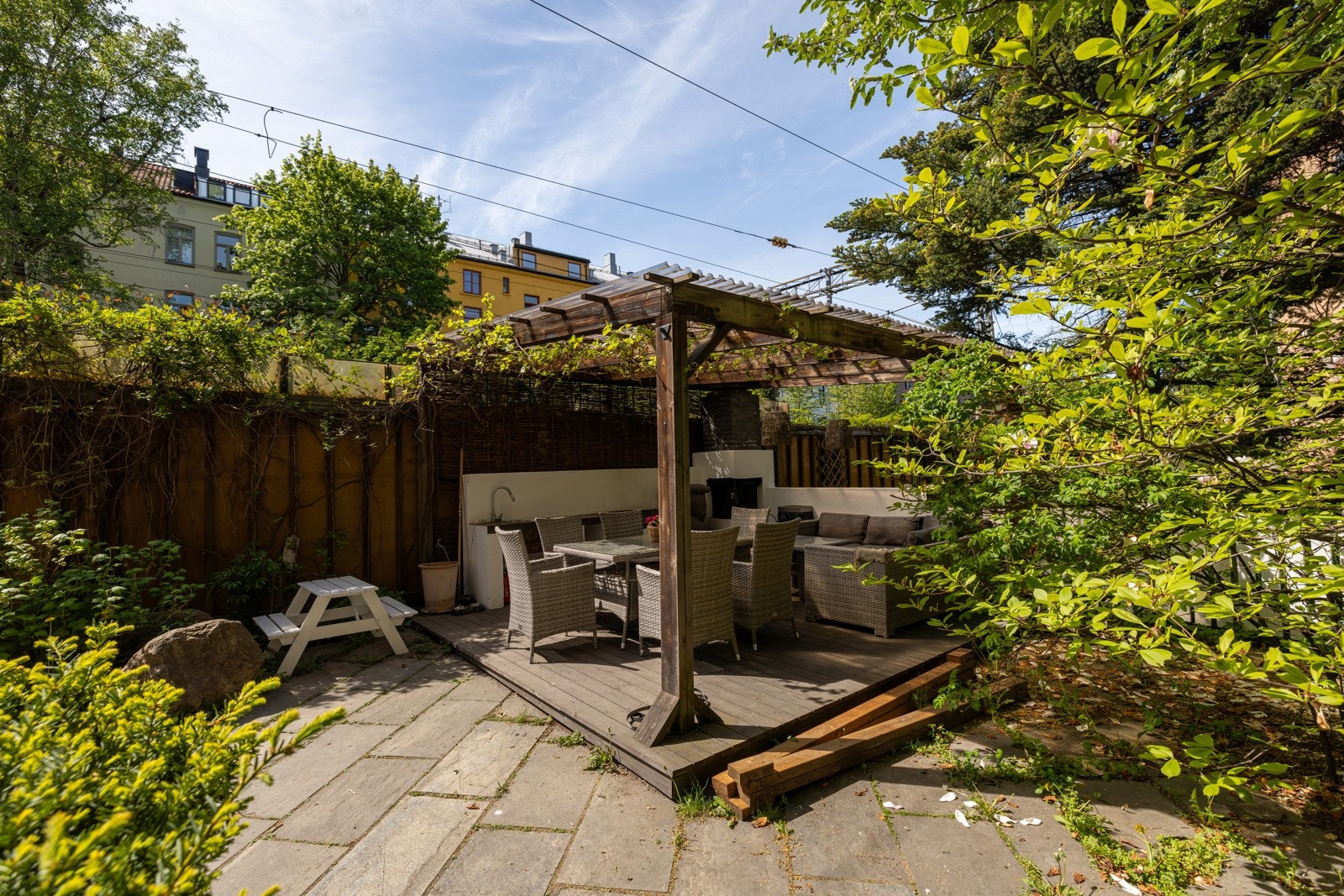 Hyggelig bakgård hvor borettslaget har en pergola over sittegruppen Galleribilde