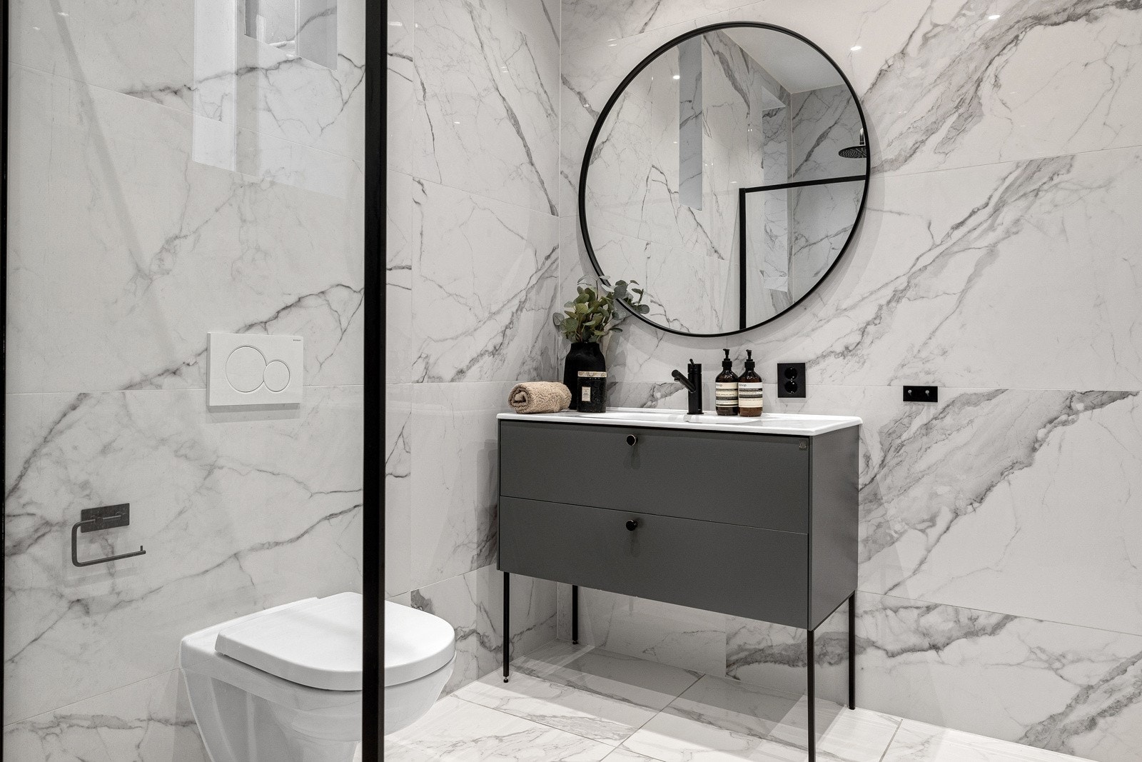 Badet er flisbelagt med lekre marmorfliser på vegger i stilig kontrast til gulvflisene. Det er elektriske varmekabler i gulv. Galleribilde