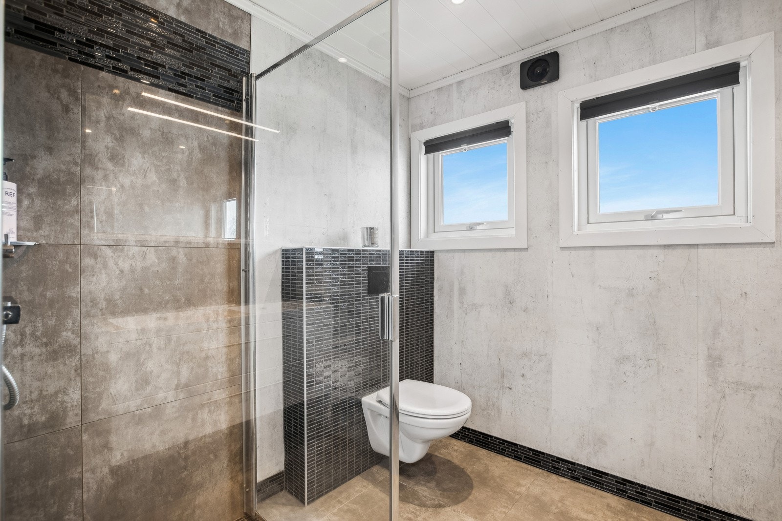 Badet i 1. etasje har flislagt gulv og vegger i dusjhjørne. Øvrige vegger er kledd med våtromsplater. Galleribilde