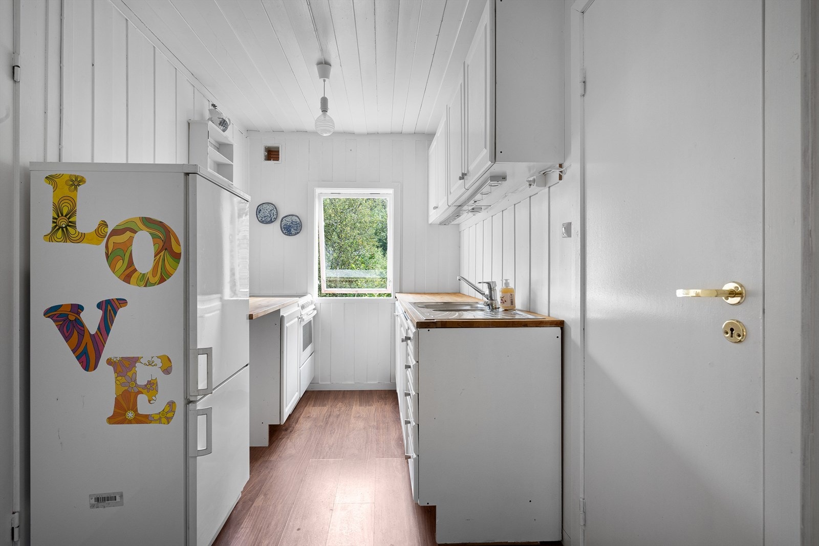 Kjøkkeninnredning med profilerte fronter, heltre benkeplate med nedfelt vask og komfyr. Galleribilde