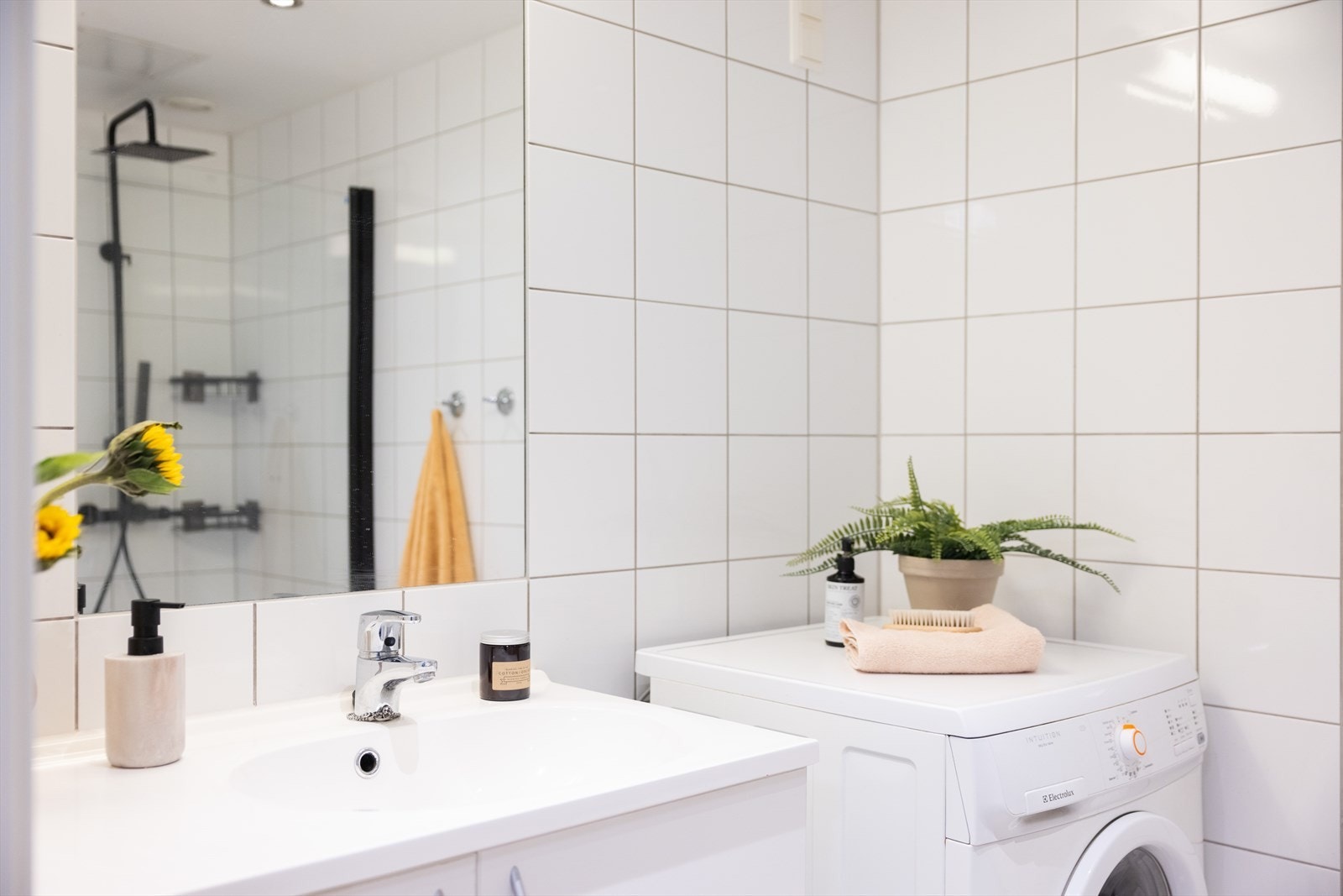 Badet inneholder vegghengt toalett, servant med innredning, dusjhjørne og opplegg for vaskemaskin. Galleribilde