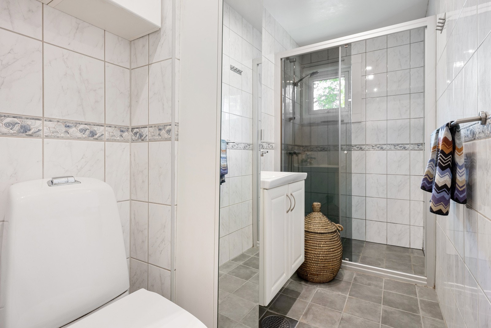 Lyst flislagt baderom med varmekabler og downlights. Galleribilde