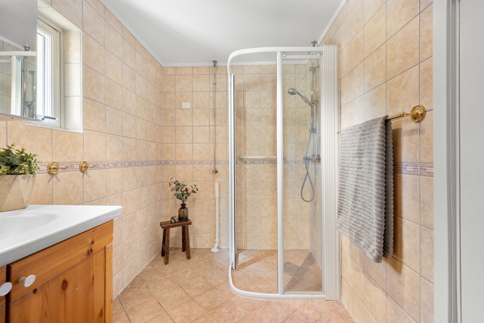 Badet har dusjhjørne med skyvedører, samt opplegg for vaskemaskin. Varmtvann kommer fra felles sentralanlegg. Badet større enn normalt. Galleribilde