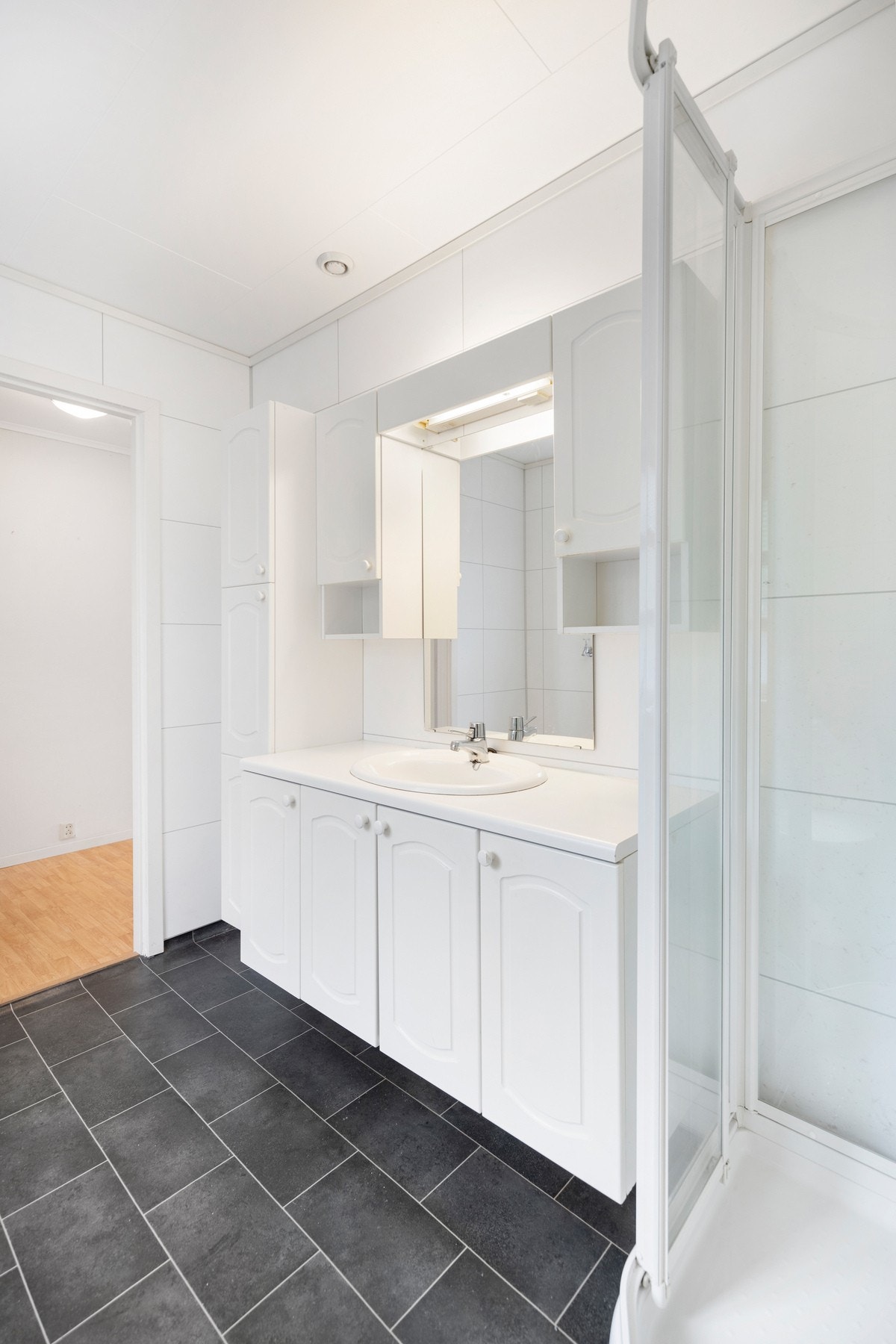 Rommet er utstyrt med varmekabler i gulv, dusjkabinett, toalett fra 2023, opplegg for vaskemaskin/tørketrommel og baderomsinnredning med servant. Galleribilde