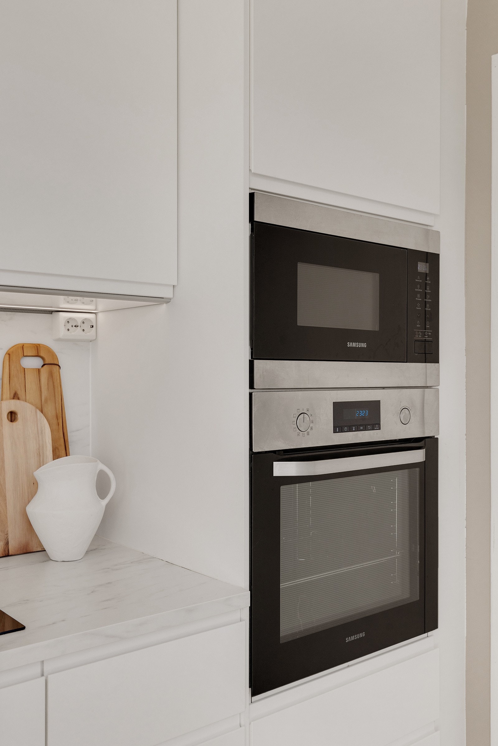 Integrerte hvitevarer som oppvaskmaskin, microovn, stekeovn, induksjon koketopp og kjøleskap med frysedel. Galleribilde