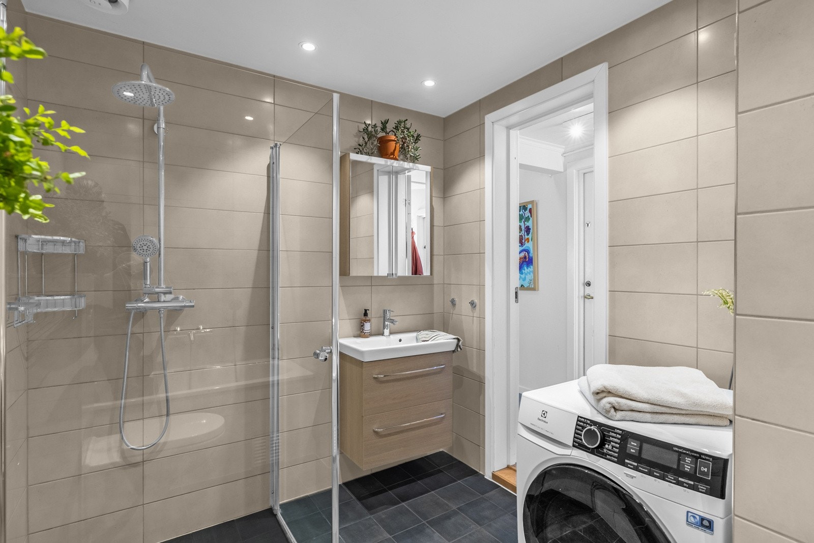 Delikat, flislagt bad med gulvvarme og downlights i taket Galleribilde