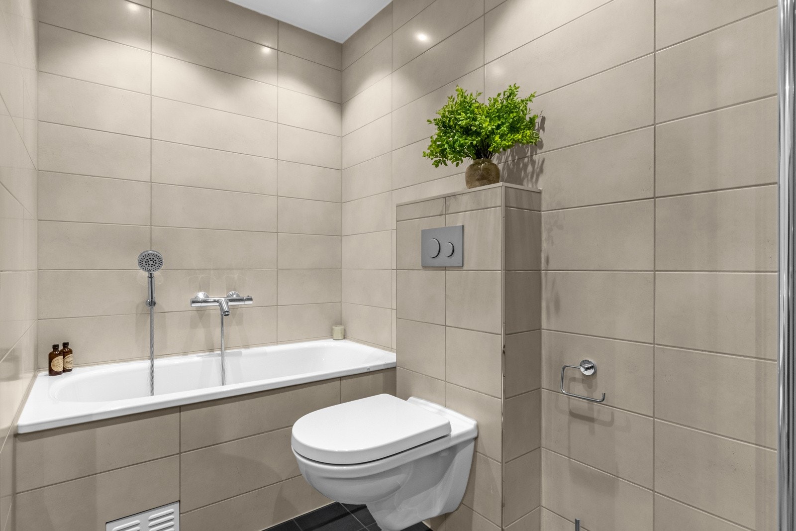 Badet har badekar og separat dusj. Innredet med tidløse, elegante fliser Galleribilde