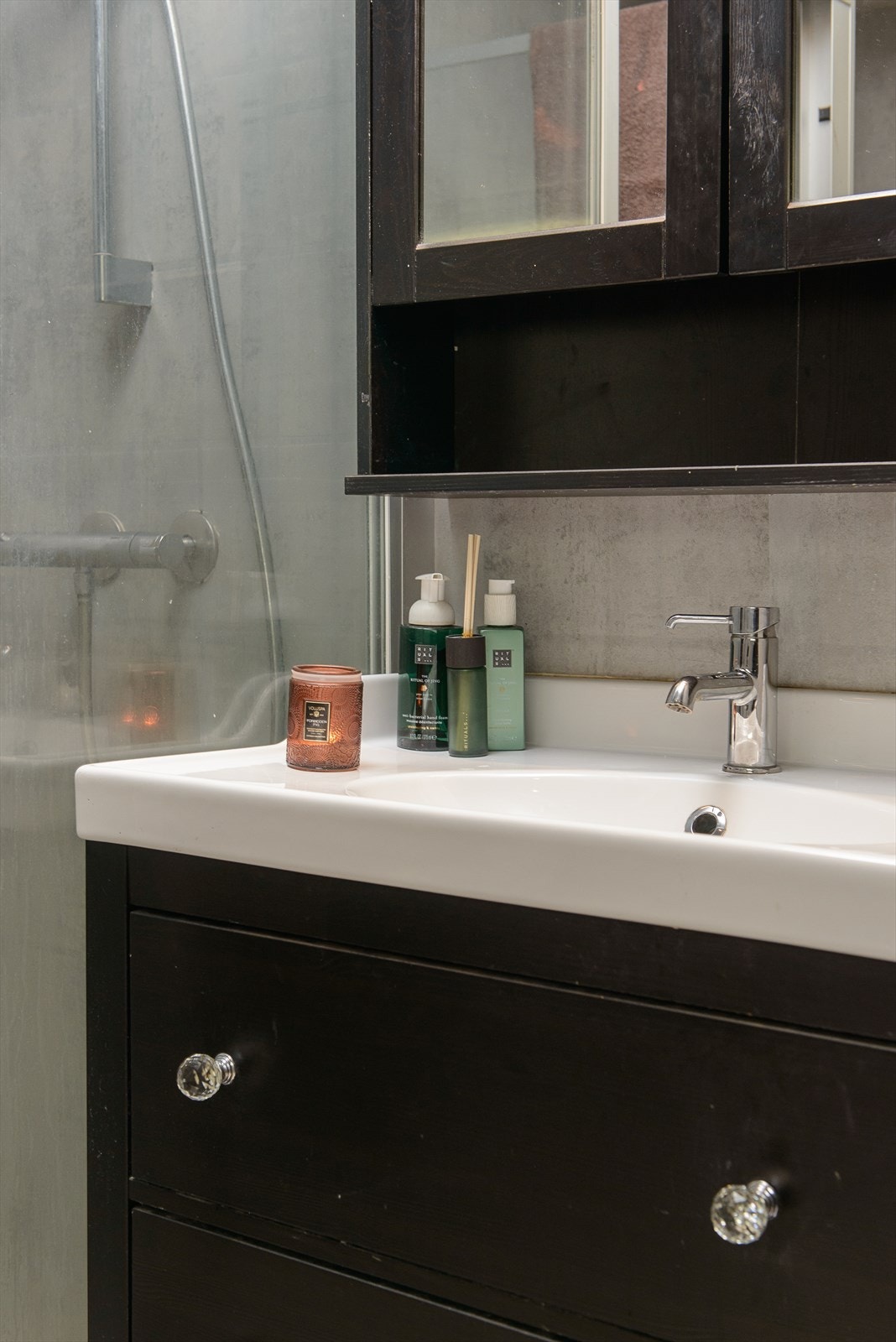 Badet har innredninger med sorte fronter, servant av porselen og ett-greps blandebatteri. Overskap med speil i frontene Galleribilde