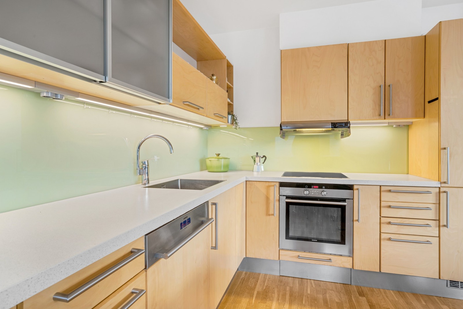 Kjøkkenet har detaljer som glass mellom over og- underskap og underlimt vask. Galleribilde