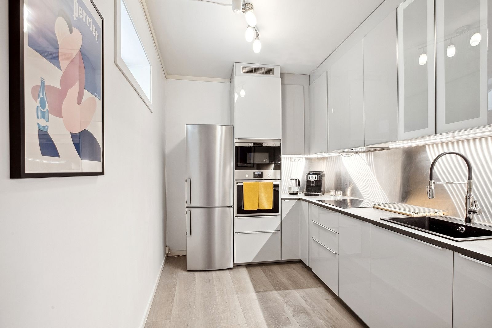 Kjøkken med kjøleskap, oppvaskmaskin, komfyr, platetopp & mikro Galleribilde