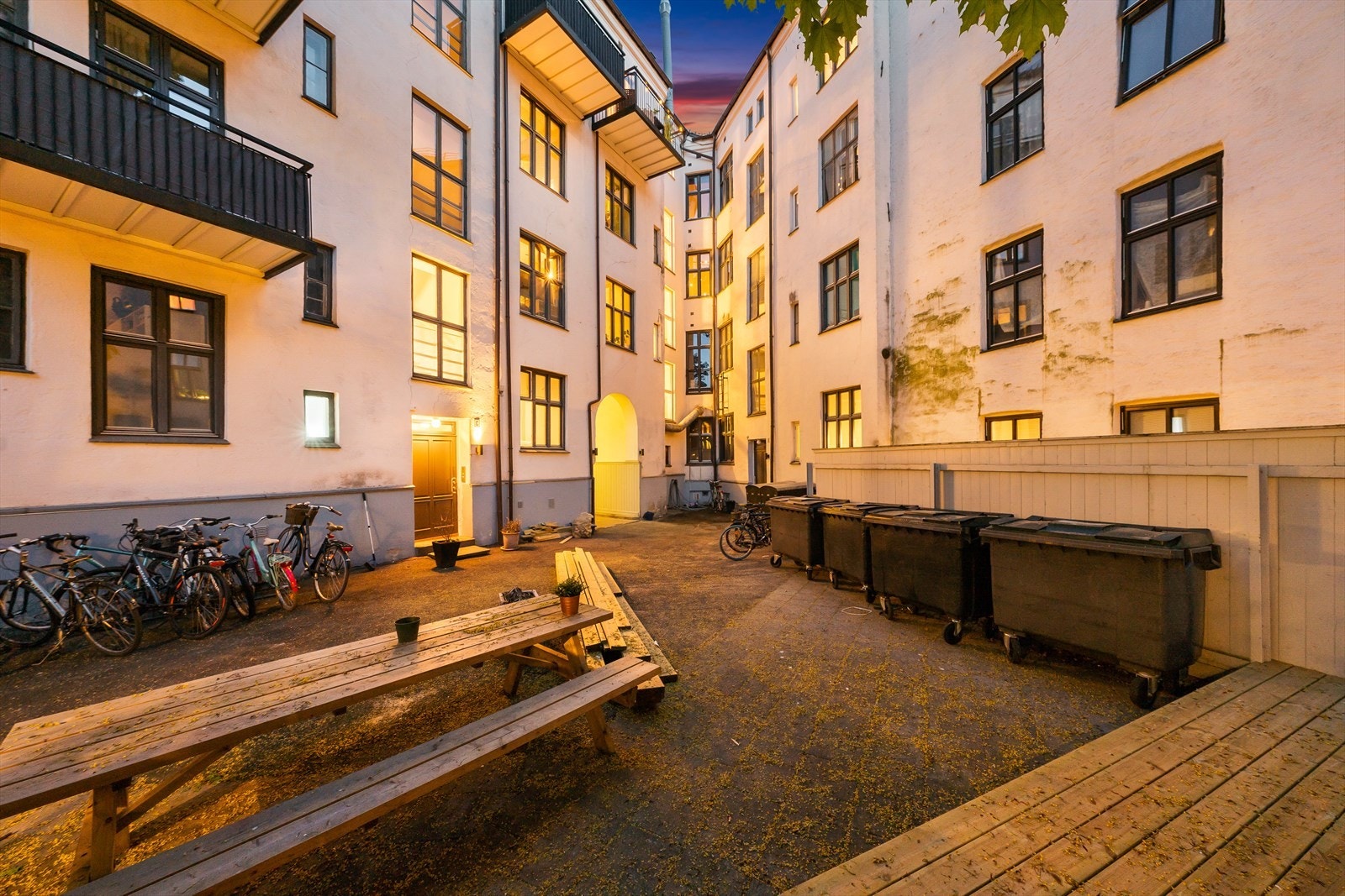 Bygningens bakgård med sykkelparkering og sitteplasser Galleribilde