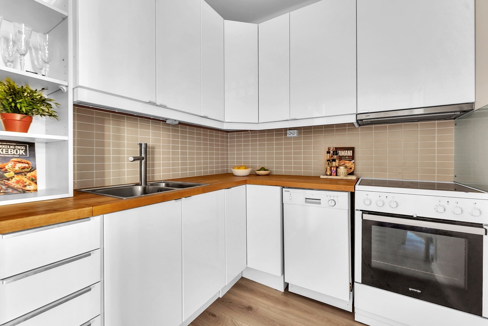 Lys, moderne innredning med glatte fronter og benkeplate i heltre eik. Galleribilde