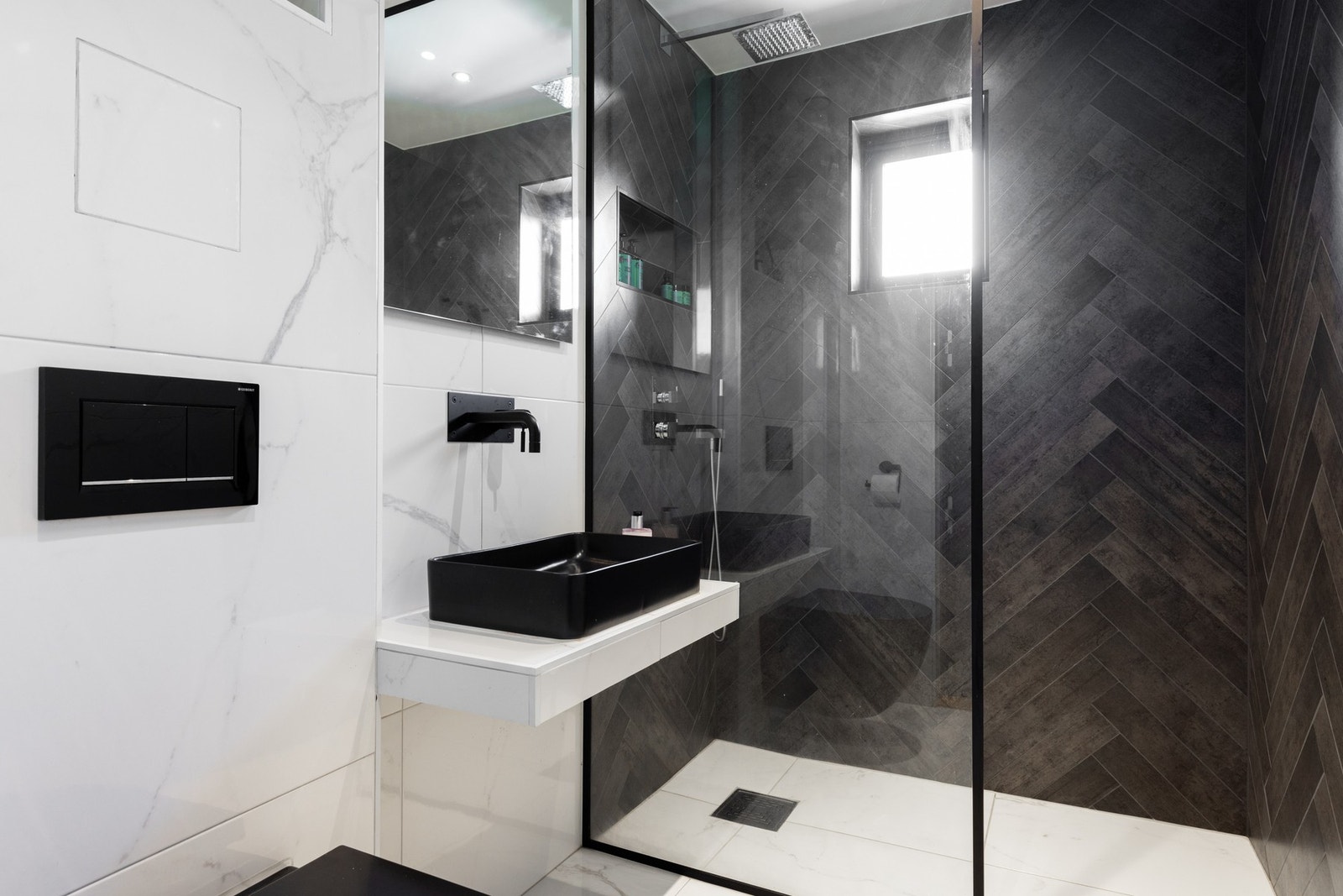 Regnfallsdusj og veggmontert blandebatteri med skjulte rør i veggen gir badet et delikat og lekkert preg. Galleribilde