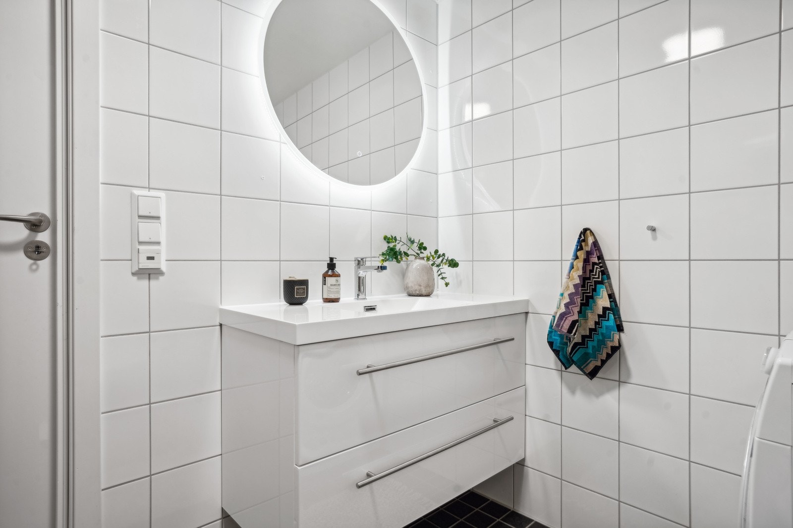 Bad med speil med lys på vegg over servant med innredning Galleribilde