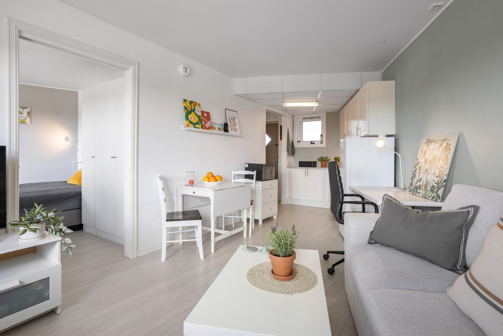 Stue og kjøkken i åpen løsning, med moderne laminatgulv gjennomgående i alle rom. Galleribilde