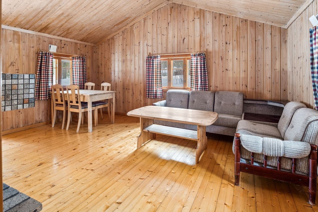 Stuen er belagt med furugulv og trepanel på vegger og tak. Galleribilde