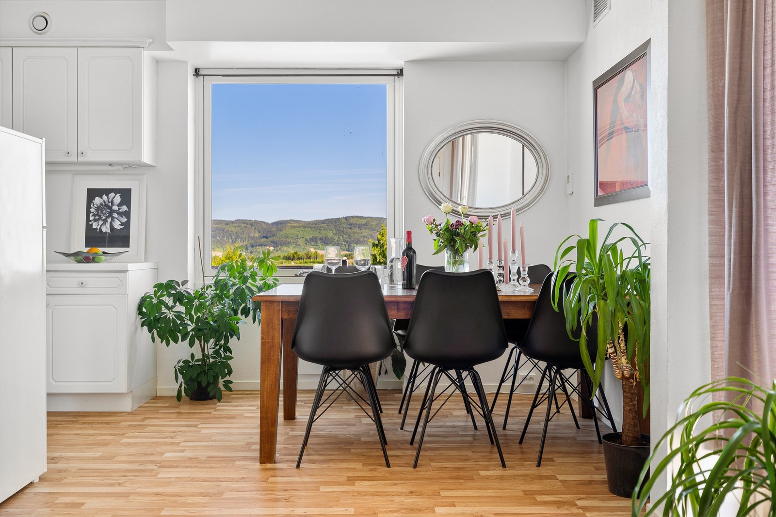 Naturlig avdeling av stue og kjøkken med spisebord for sosiale sammenkomster. Galleribilde