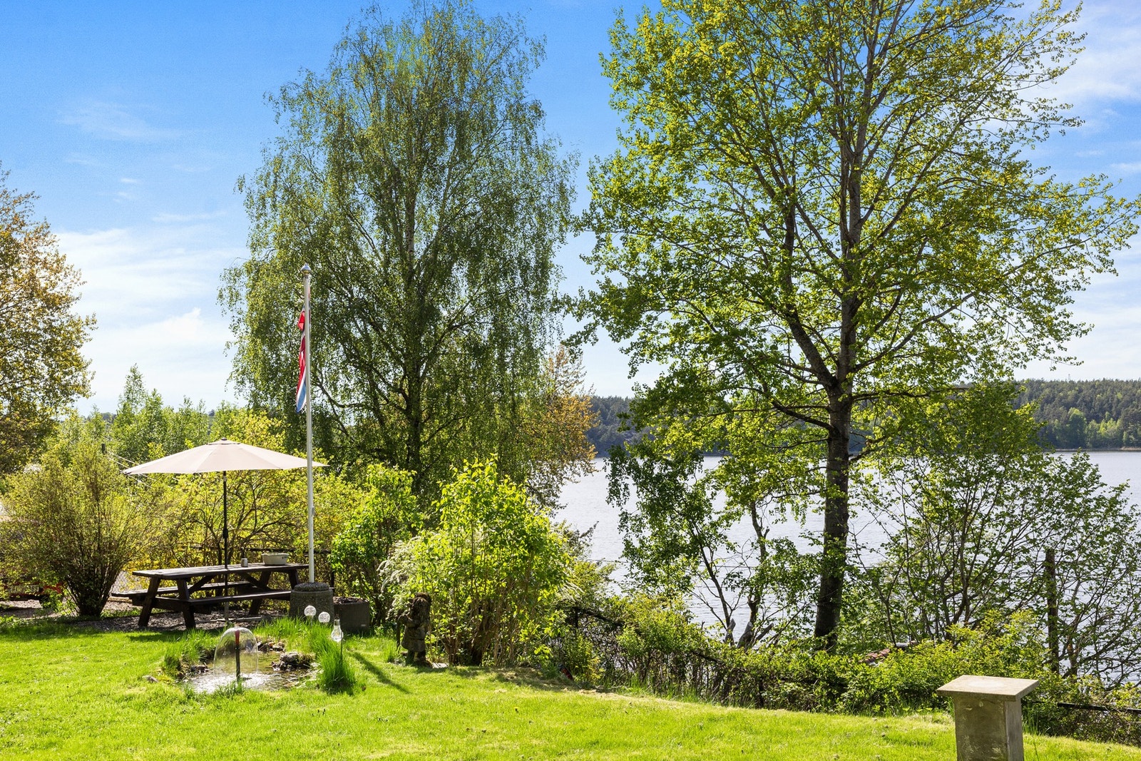 Tomten er pent opparbeidet med diverse beplantning, samt en fontene. Galleribilde