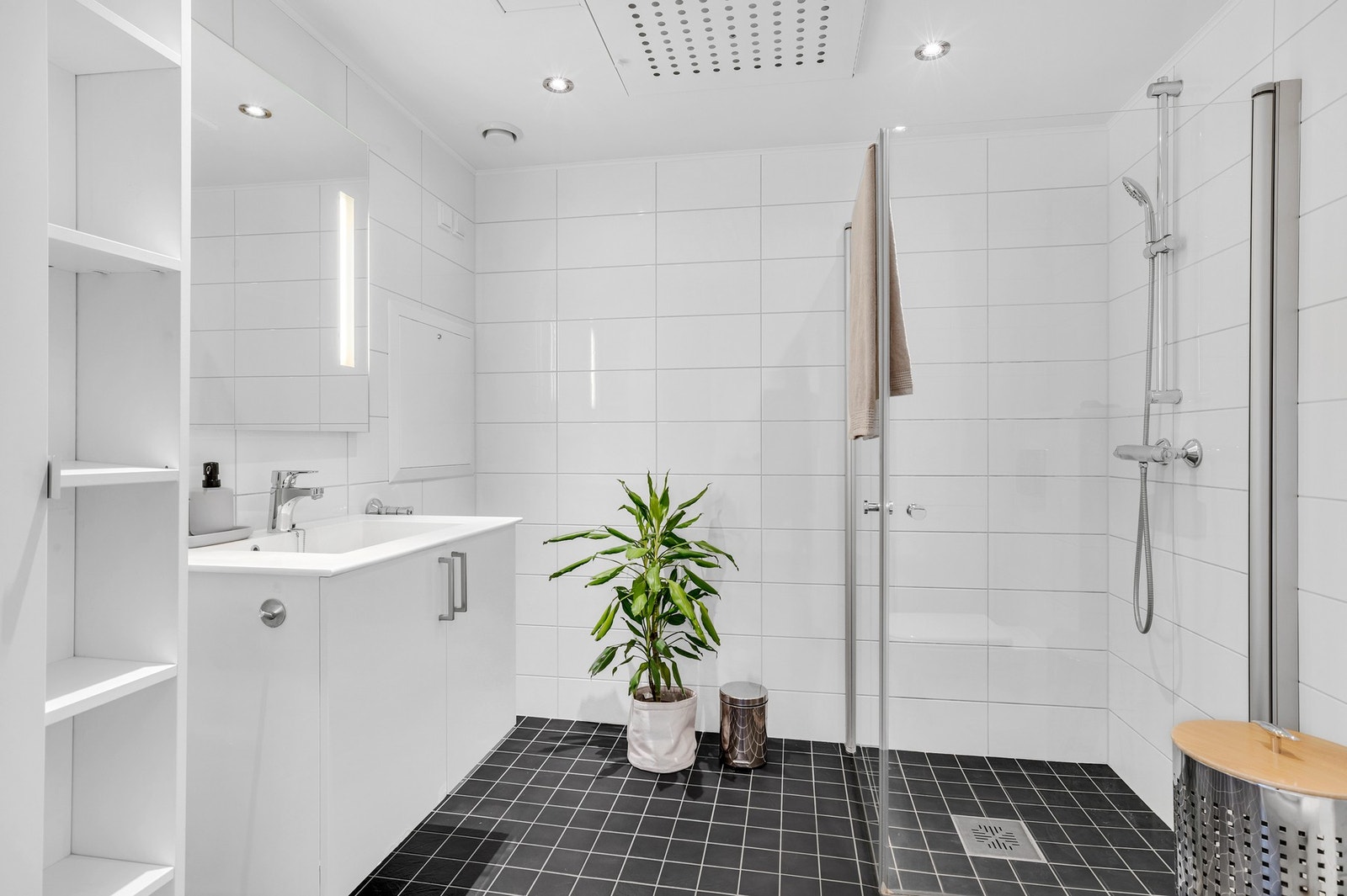 Delikat bad på ca. 5 kvm med vegghengt innredning og en praktisk dusjnisje med innfellbare dører. Galleribilde