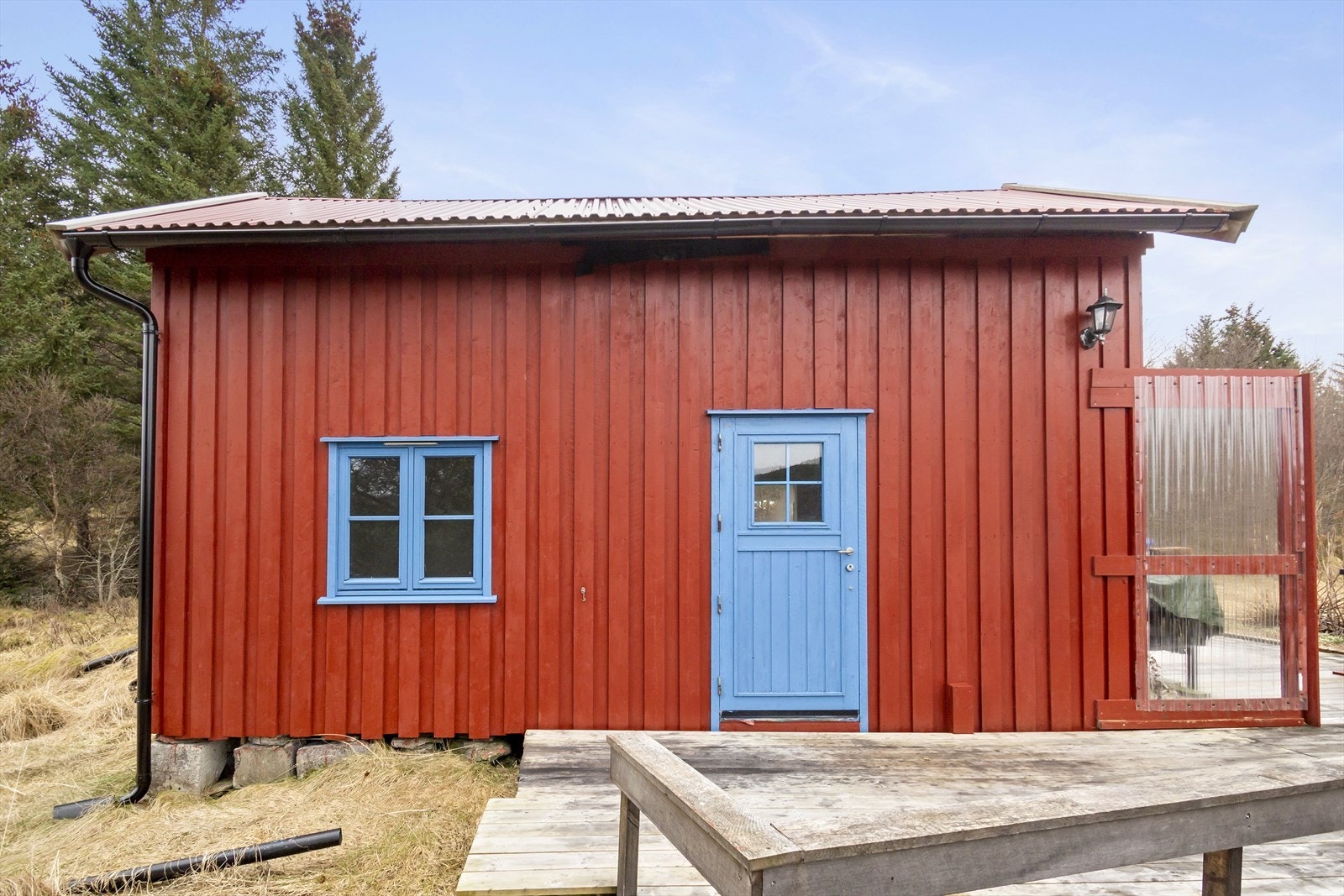 Det er bygd treplatt utenfor uthuset med trapp ned til boligen. Det er satt opp levegger både ved uthuset og ved inngangen til boligen. Her kan man fint skape seg en sittegruppe hvor man kan nyte en kopp kaffe i solveggen Galleribilde