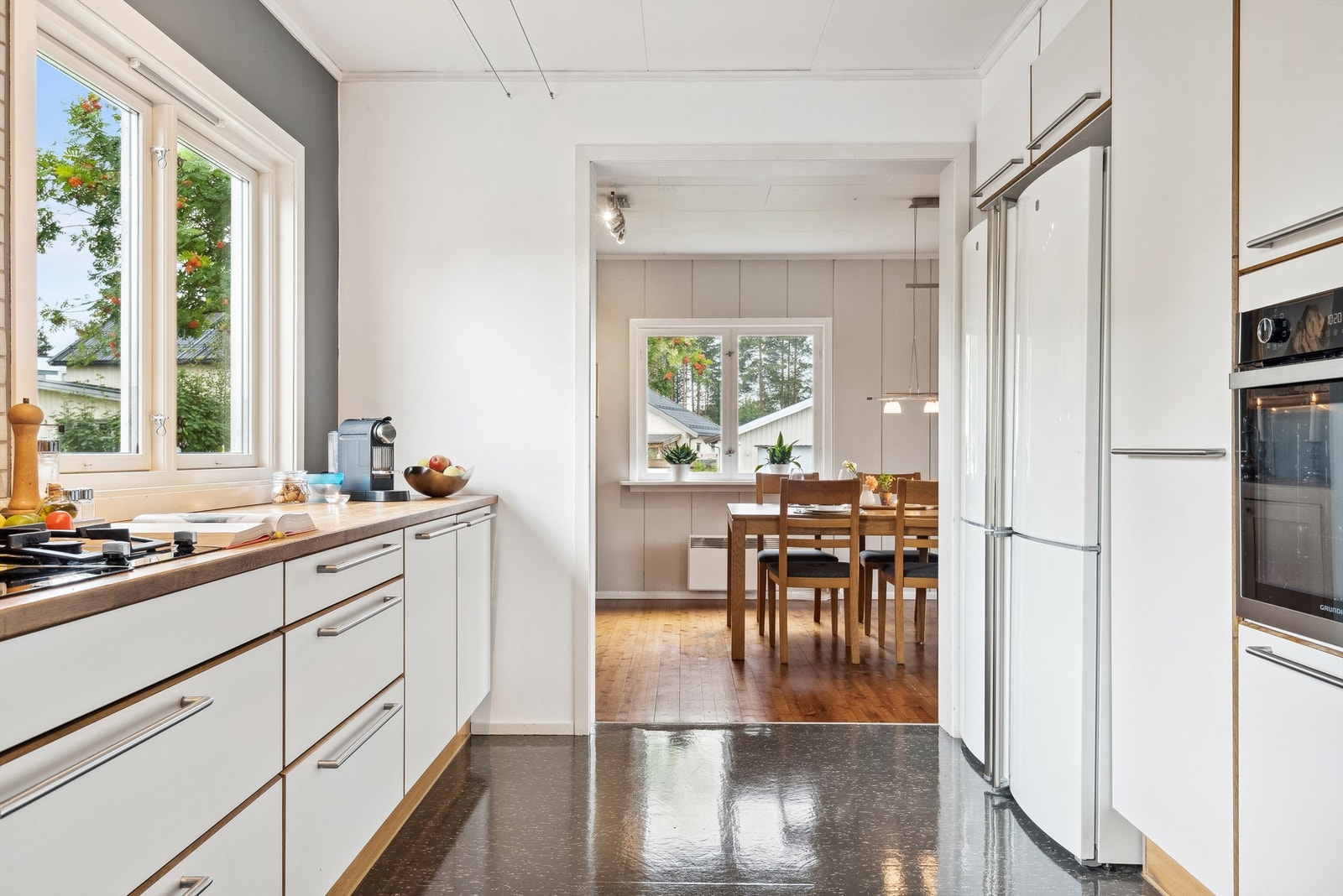 Integrerte hvitevarer som stekeovn, oppvaskmaskin og platetopp med både gassbluss og induksjonsplater. Det er også plass til frittstående hvitevarer som kjøl- og fryseskap. Galleribilde