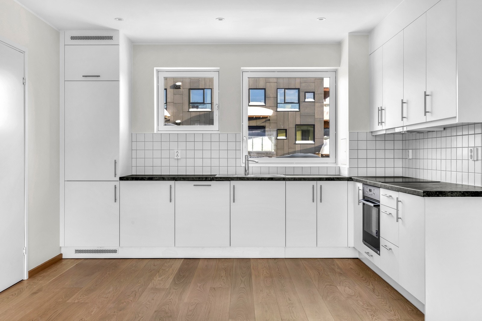 Kjøkkenet er utstyrt med moderne og elegante hvite fronter, av typen HTH og en rustfri stålkum som gir kjøkkenet et strømlinjeformet utseende. Integrerte hvitevarer fra anerkjente leverandøren AEG gir deg det praktiske du trenger. Galleribilde