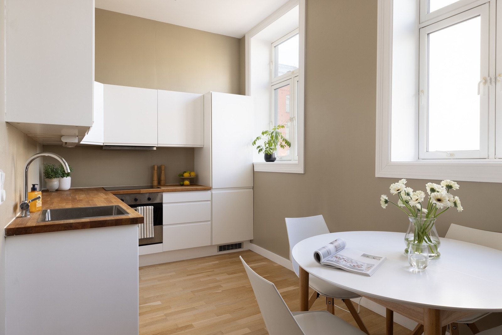 Moderne kjøkken i tilknytning til stuen. Store vinduer med brede vinduskarmer. Galleribilde