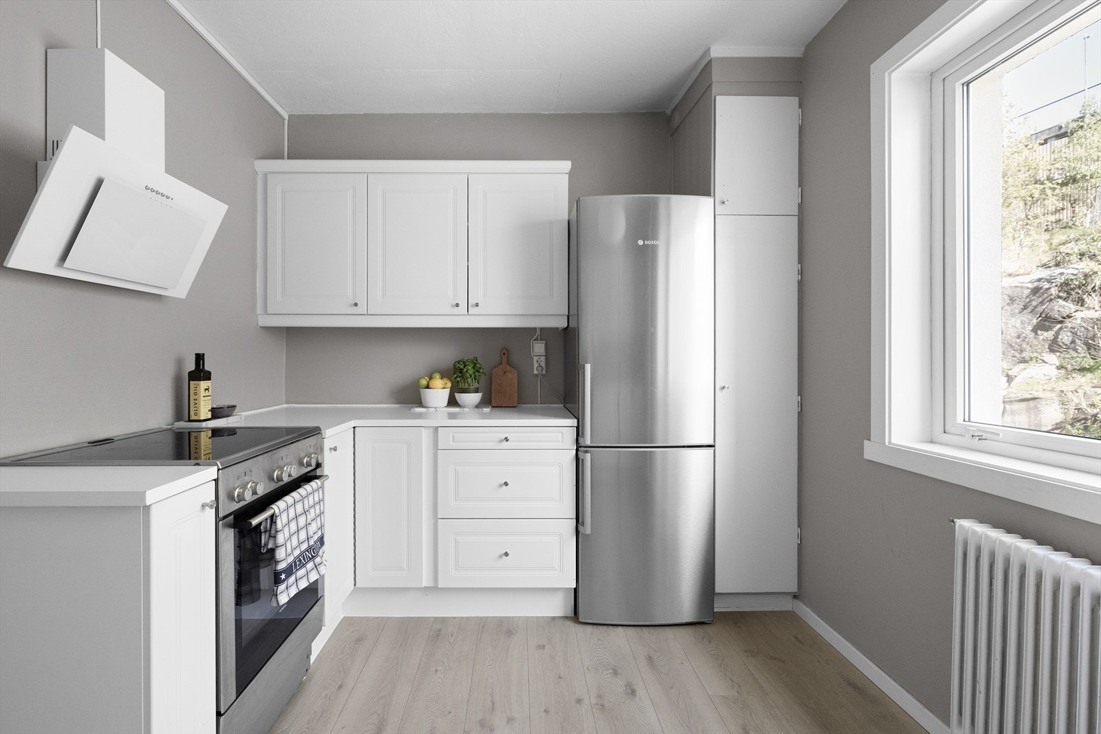 Kjøkkenet har frittstående hvitevarer med oppvaskmaskin, komfyr, kjøl/frys og vaskemaskin Galleribilde