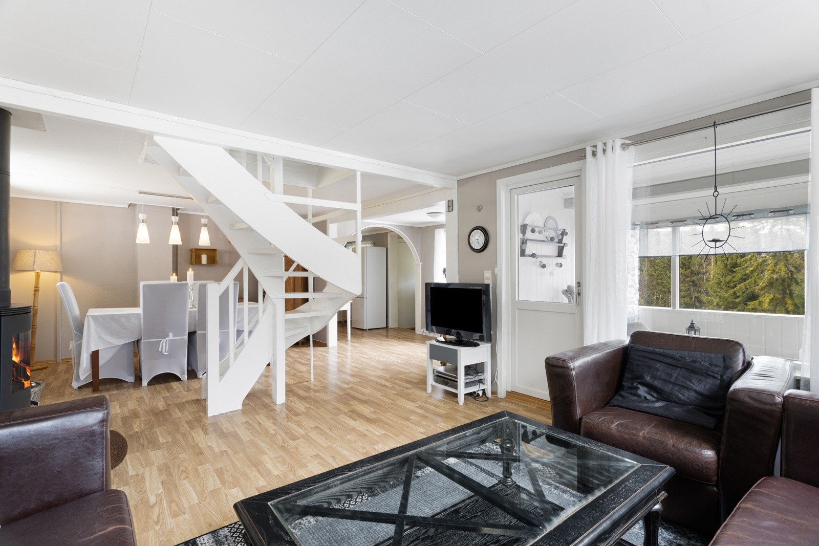 Romslig stue med god plass for både spisegruppe og tv-stue med tilhørende møblement Galleribilde