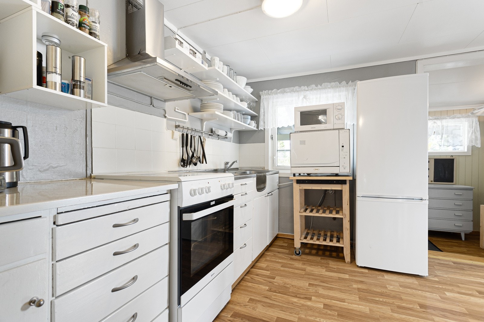 Funksjonelt og arbeidsvennlig kjøkken med frittstående hvitevarer Galleribilde