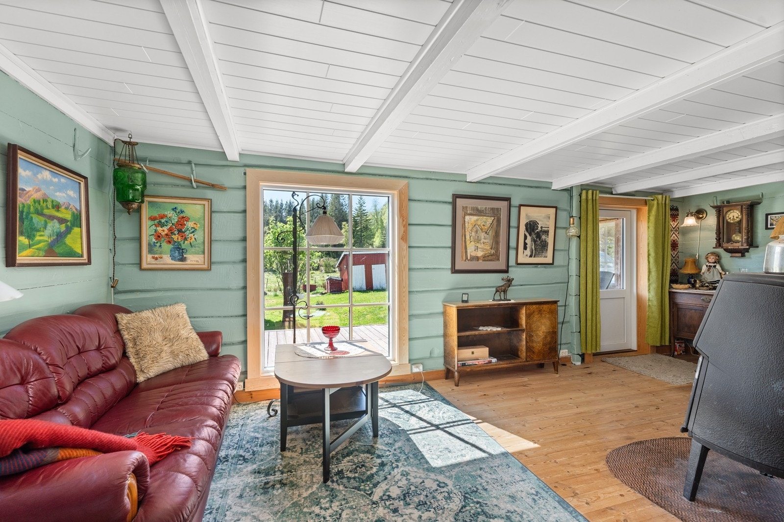 Koselig stue med laftet vegger. Her er utgang til terrasse. Galleribilde