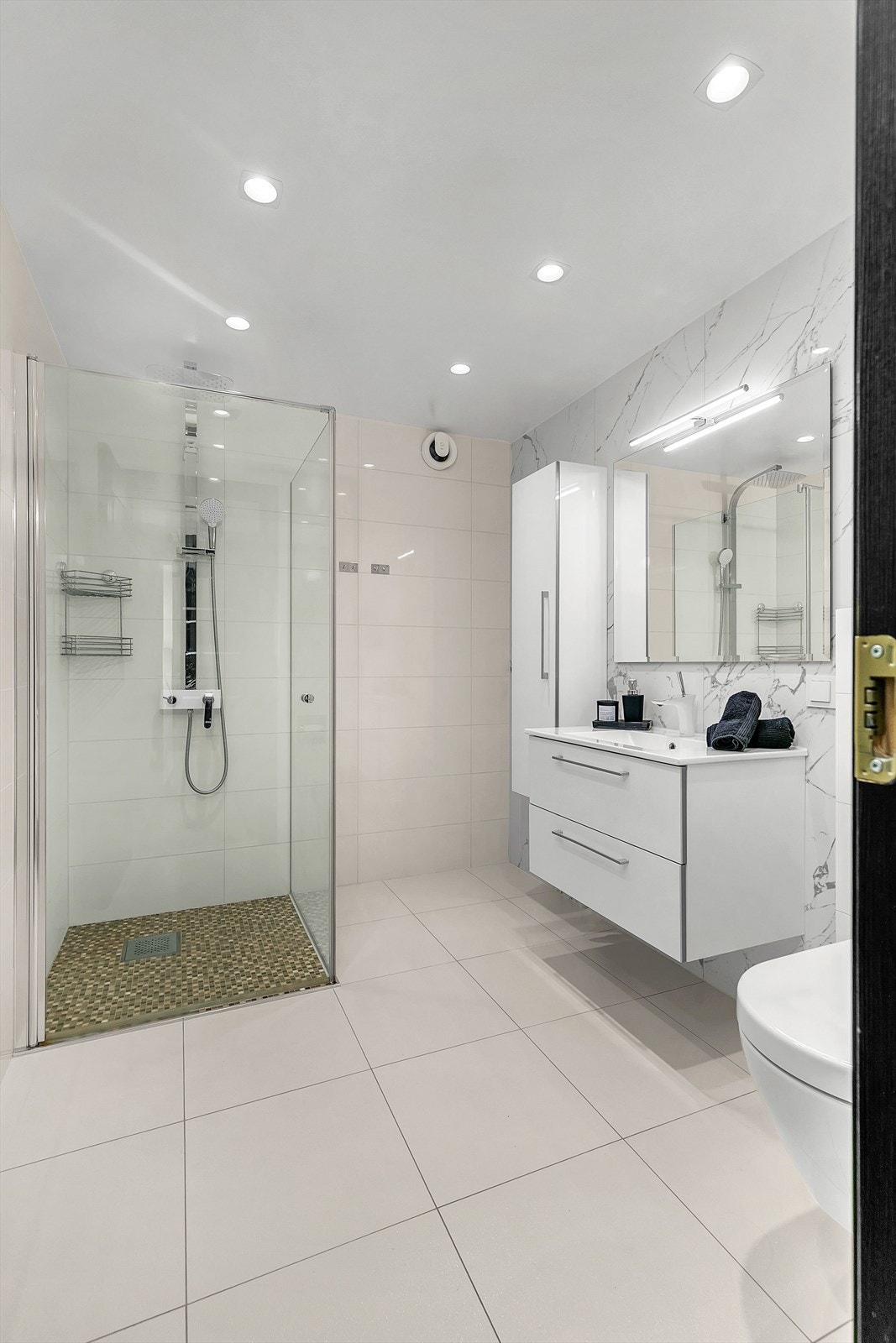 Badet er velutstyrt med servantskap, vegghengt skap, downlights i himling, dusjhjørne med rainshower og varme i gulv. Galleribilde