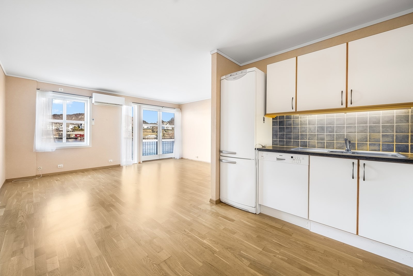 Åpen kjøkkenløsning med plass til spisebord mellom sonene. Galleribilde