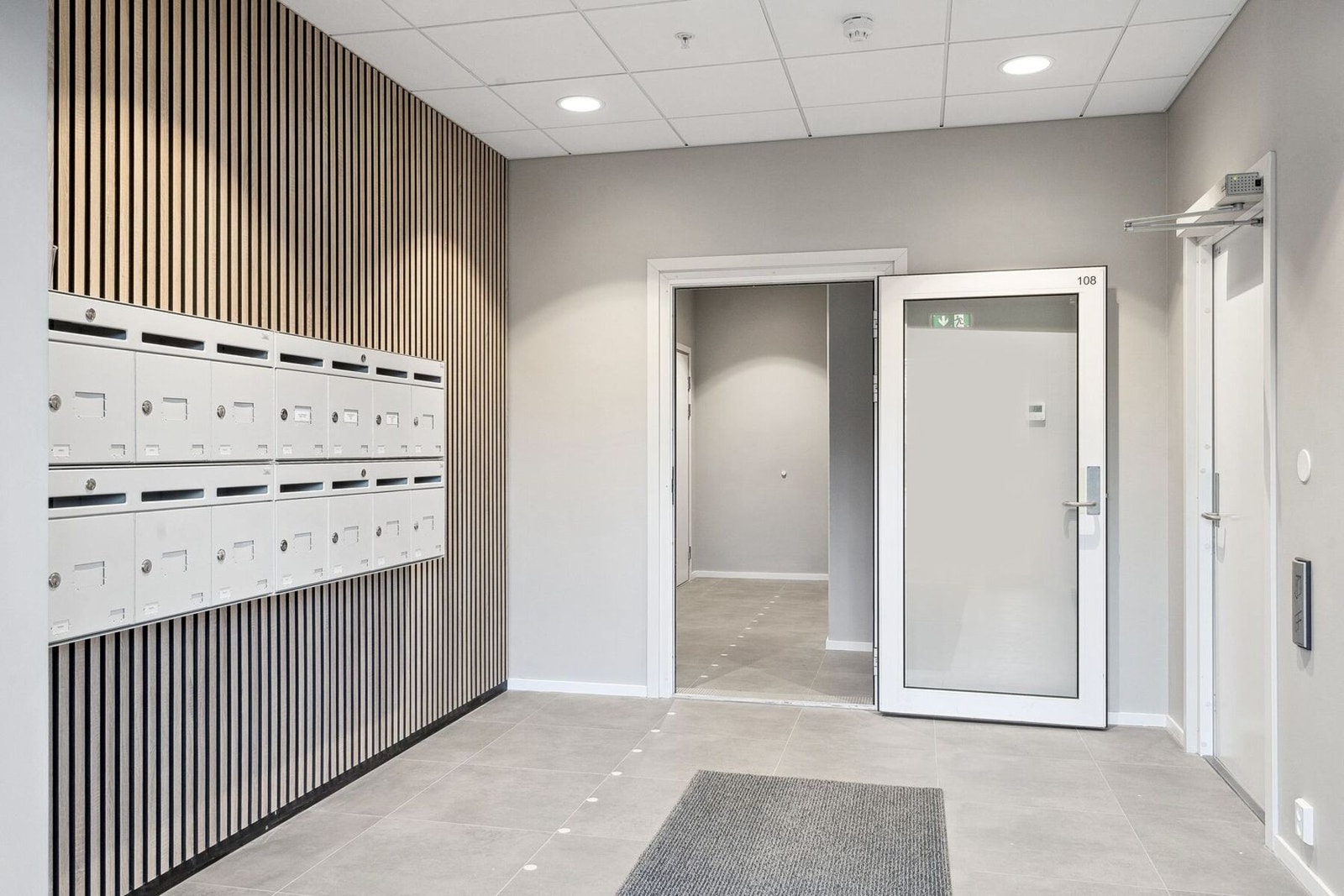 Inngangen til bygget med postbokser på venstre side, garasje høyre side og trapperom med heis rett fram. Galleribilde