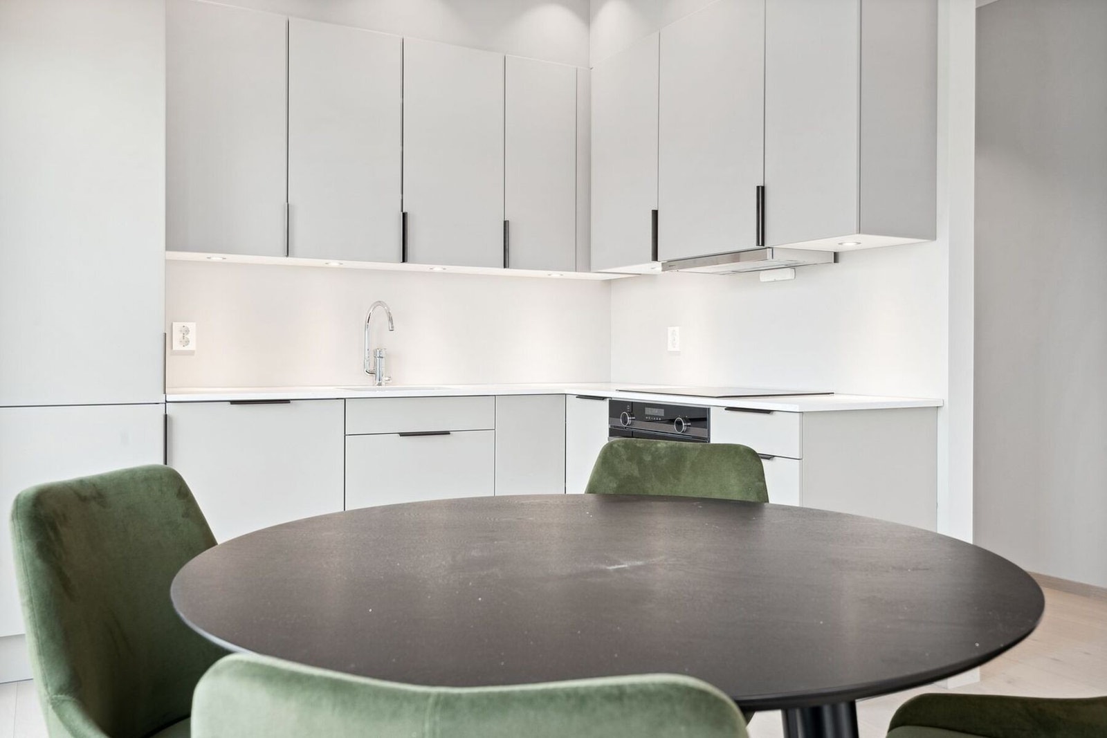 Stilrent kjøkken fra JKE. Benkeplate i komposittstein som er sterk og vedlikeholdsfritt Godt arbeidslys med spotter i taket og under overskapene. Galleribilde