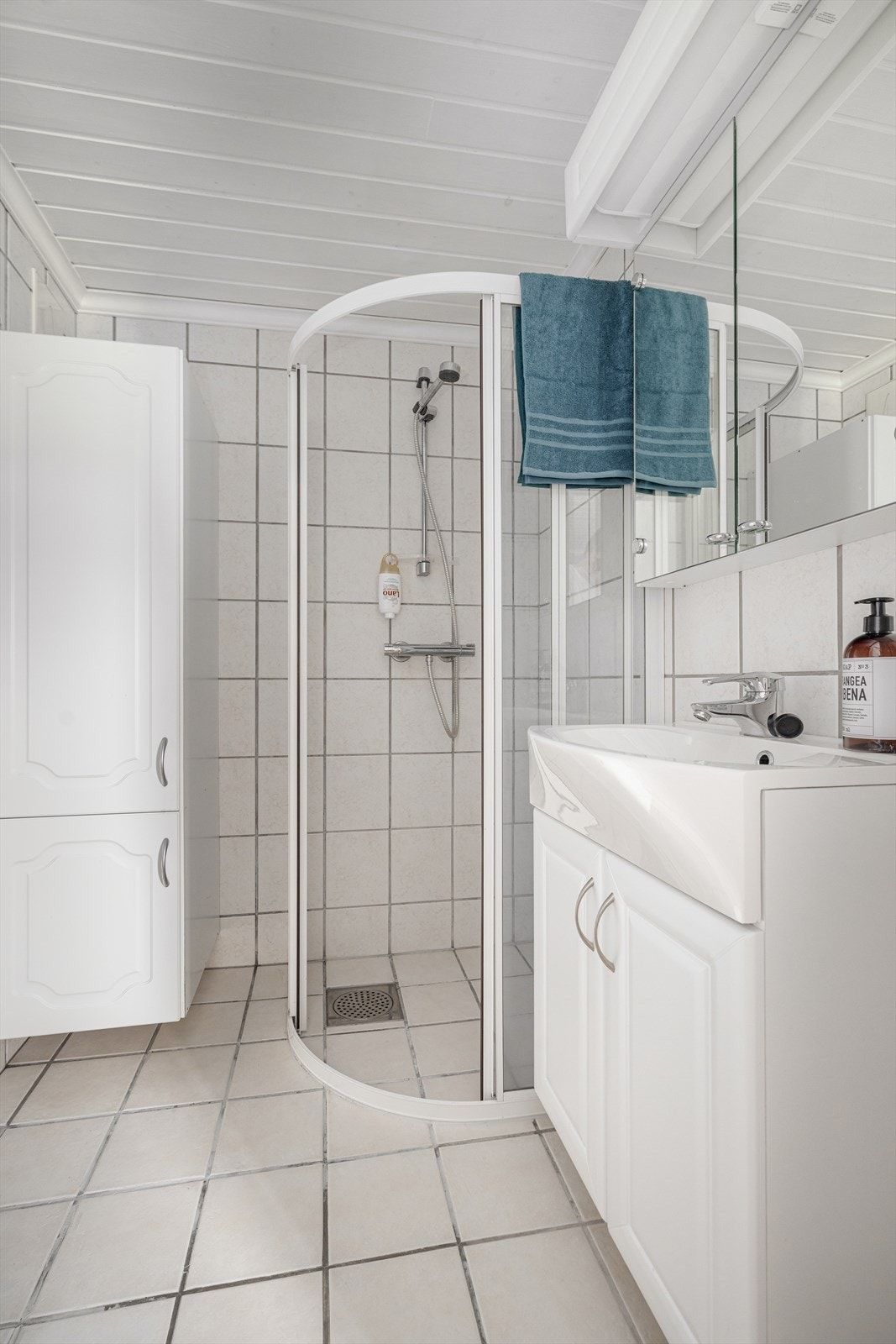 Det tilliggende dusjrommet er helfliset med varmekabler i gulv, og har innredning med servant samt høyskap. Her er det også dusjhjørne. Galleribilde