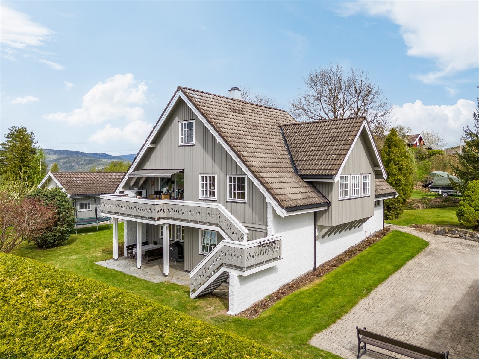 Den romslige tomten er svært pent opparbeidet med frodige grøntarealer, dekorative bed, prydbusker og vintergrønne hekker. Galleribilde