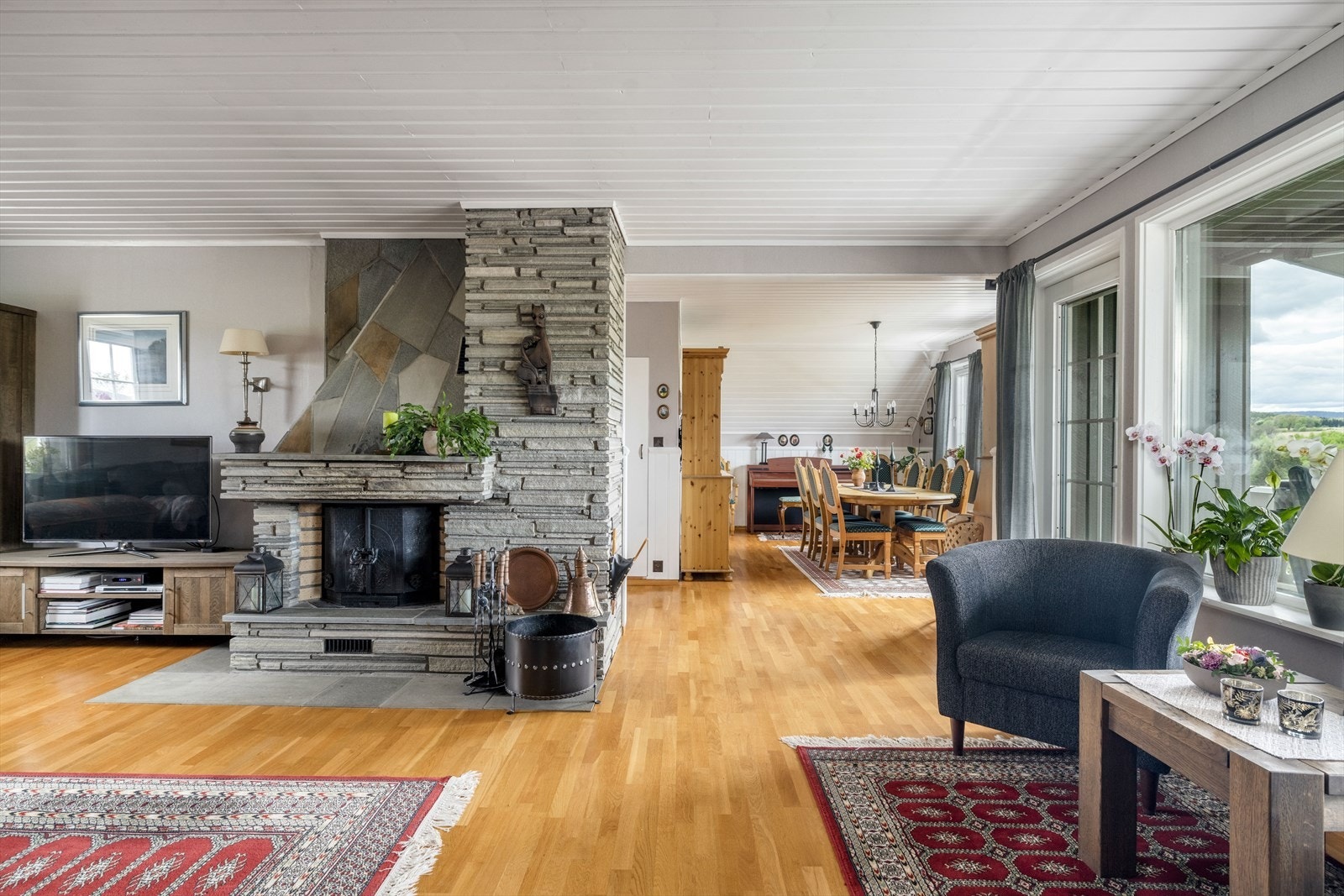 Sentralt i rommet er det en dekorativ skiferpeis med peisinnsats. Det ble i 2020 også installert varmepumpe for en jevn og behagelig varme. Galleribilde