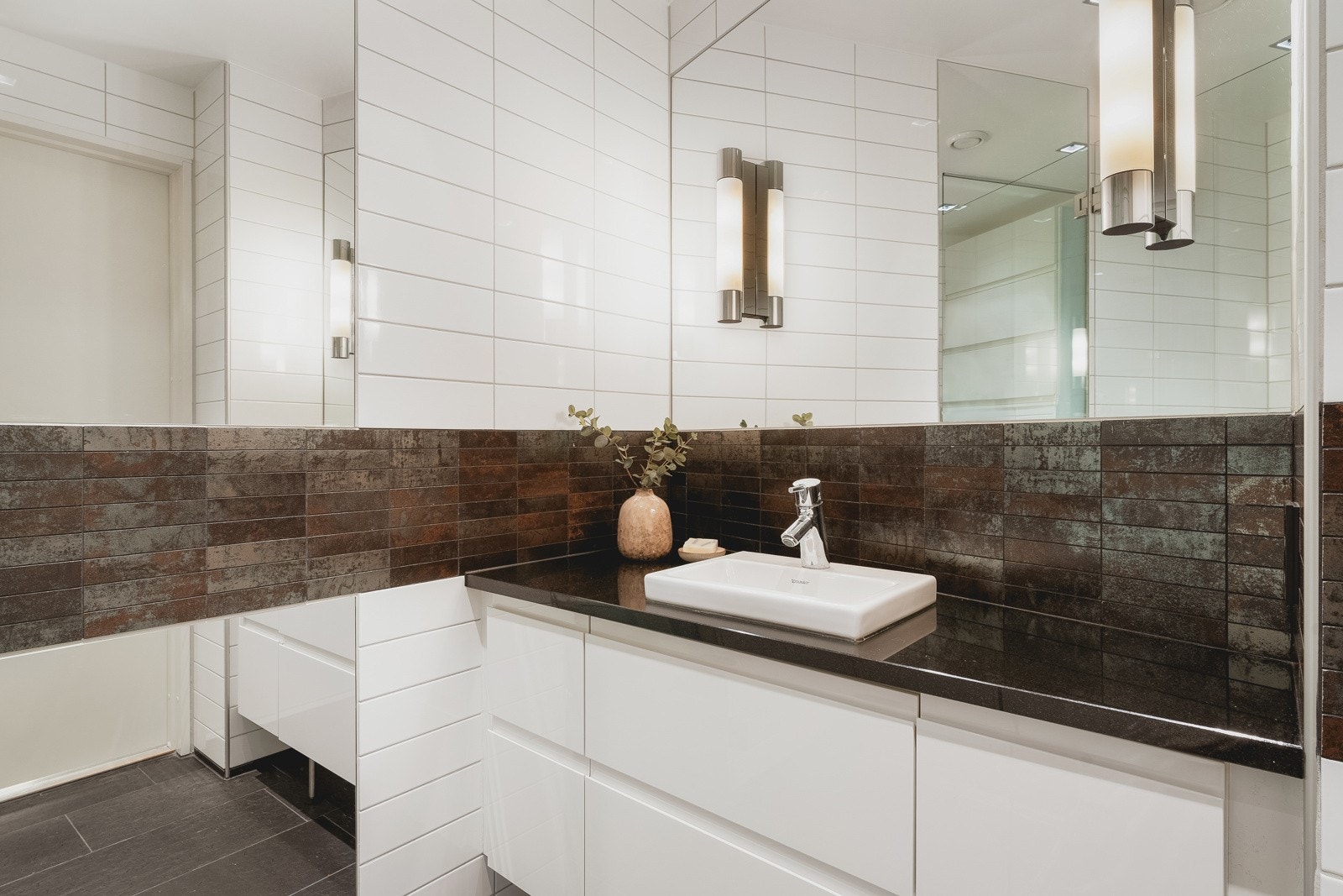 Bad 2 er utført med de samme stilrene fliser som går igjen i leiligheten. Galleribilde