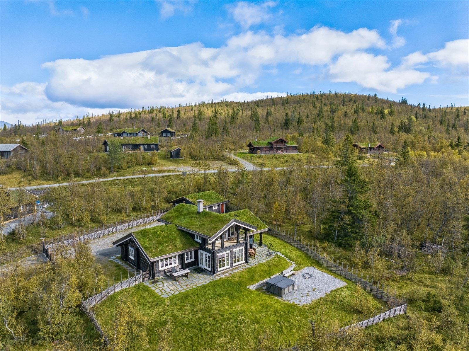 Fint opparbeidet eiendom med gode uteplasser, pent rammet inn av en skigard. Galleribilde